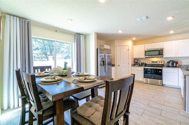 dining space featuring a textured ceiling