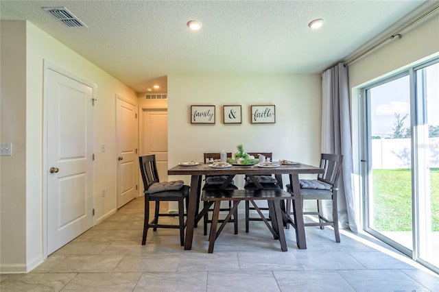 dining space with a textured ceiling and a wealth of natural light