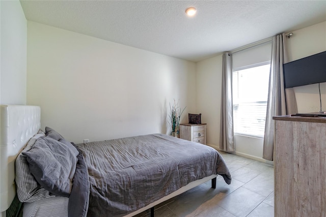 tiled bedroom featuring a textured ceiling