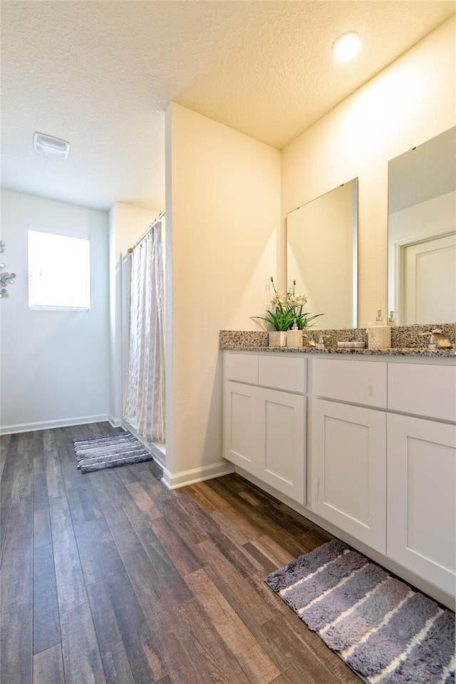 bathroom with vanity, a textured ceiling, hardwood / wood-style flooring, and a shower with shower curtain