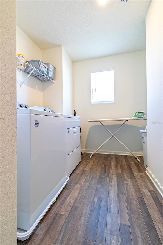 laundry area featuring a textured ceiling, dark hardwood / wood-style flooring, and washer and clothes dryer