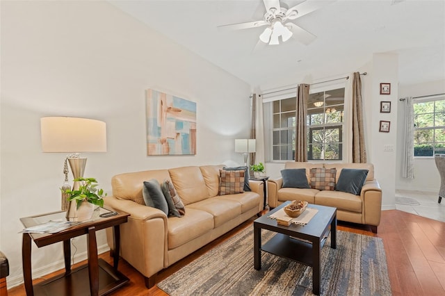 living room featuring ceiling fan, wood-type flooring, and vaulted ceiling