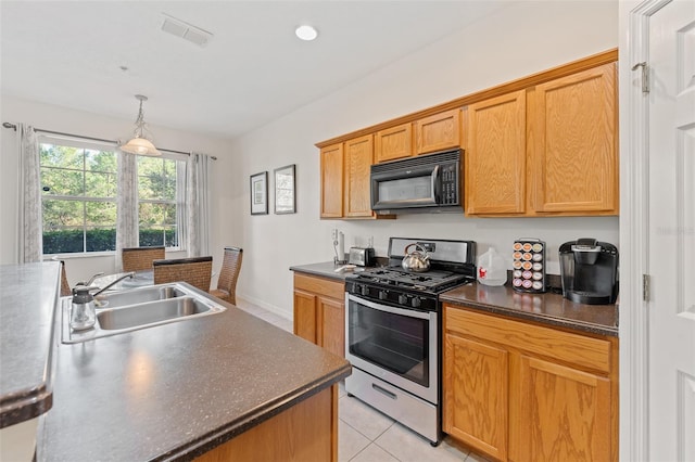 kitchen with stainless steel gas stove, light tile patterned floors, decorative light fixtures, and sink