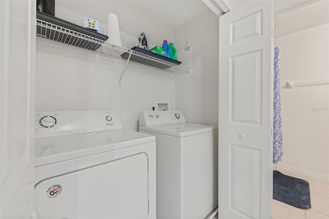 laundry area with washer and dryer and light tile patterned flooring