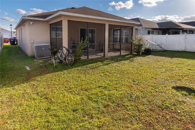 back of house featuring a sunroom, a lawn, a patio area, and central air condition unit