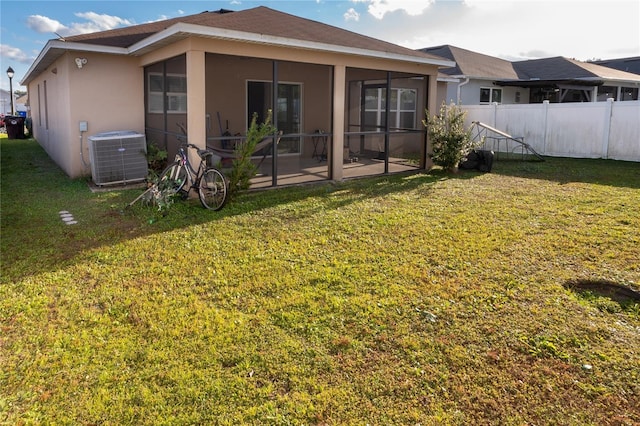 rear view of house featuring a lawn, a patio area, a sunroom, and cooling unit