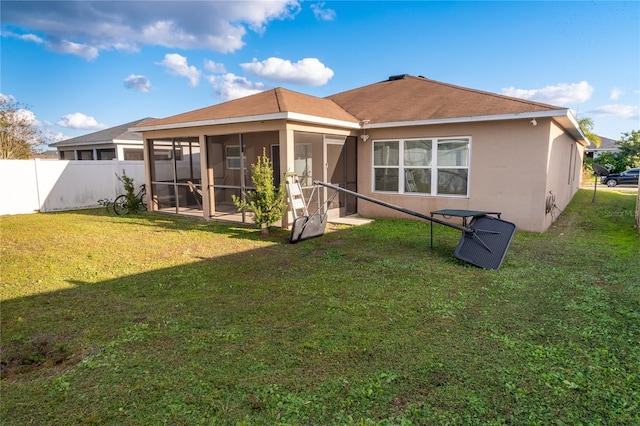 rear view of property featuring a sunroom and a yard