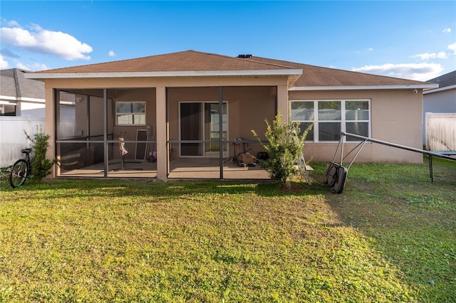 rear view of house with a yard, a patio area, and a sunroom