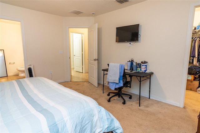 bedroom featuring a spacious closet, light carpet, and a closet