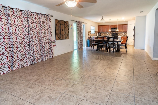 dining space with ceiling fan and light tile patterned flooring