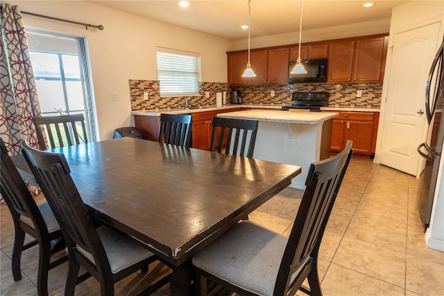 dining area featuring sink and light tile patterned flooring