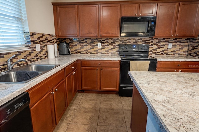 kitchen featuring decorative backsplash, sink, light stone counters, and black appliances