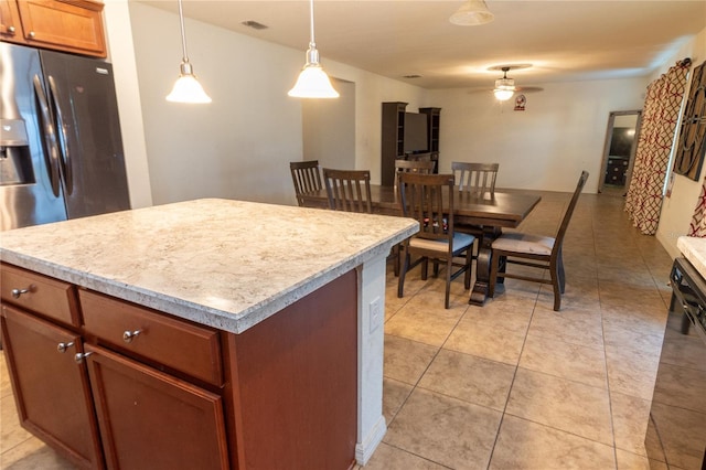 kitchen featuring ceiling fan, decorative light fixtures, black dishwasher, a kitchen island, and light tile patterned flooring