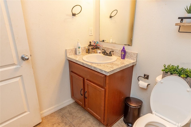 bathroom with tile patterned flooring, vanity, and toilet