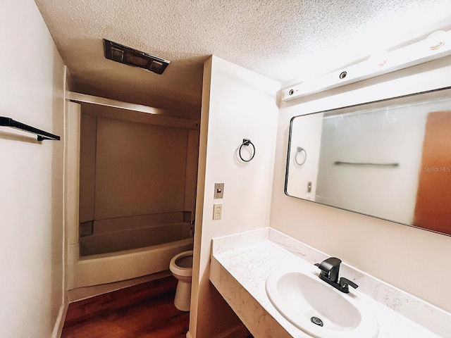 bathroom with vanity, wood-type flooring, a textured ceiling, and toilet