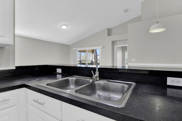 kitchen featuring white cabinets, decorative light fixtures, sink, and vaulted ceiling