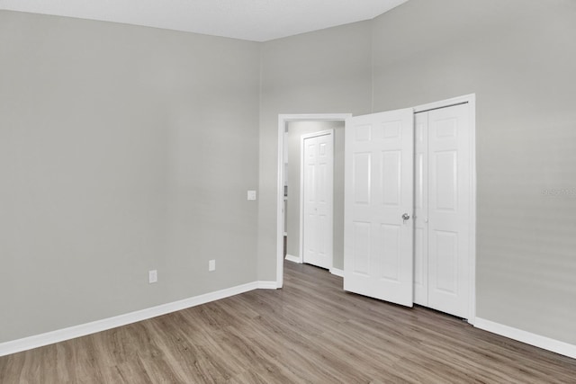 unfurnished bedroom with hardwood / wood-style floors and a closet