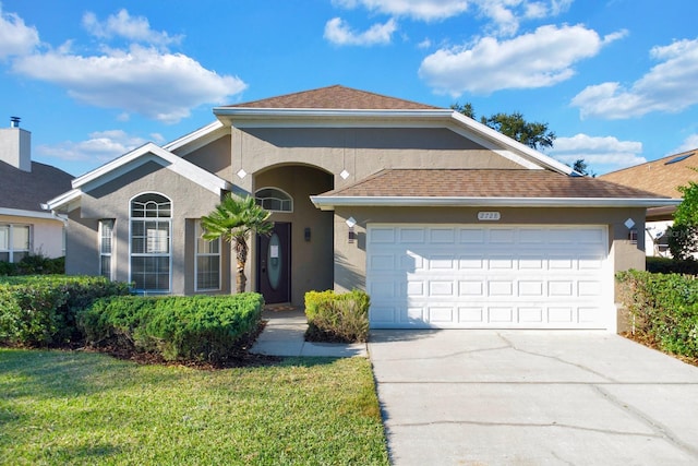 view of front of house featuring a garage and a front lawn