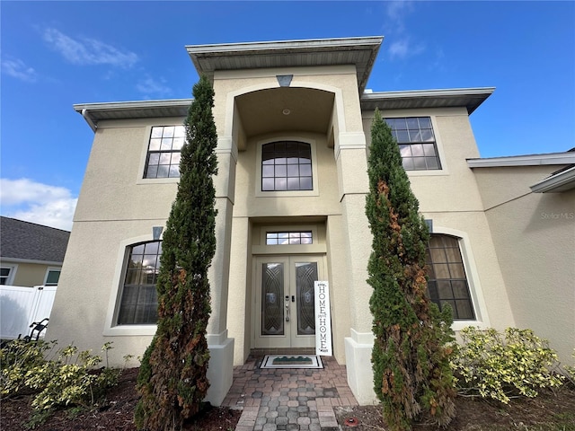 view of exterior entry with french doors and stucco siding