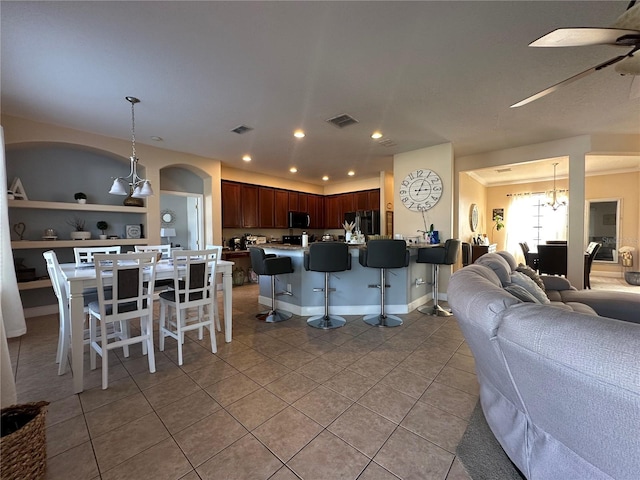 interior space with built in features, light tile patterned flooring, and ceiling fan with notable chandelier