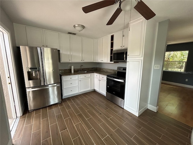 kitchen featuring sink, dark hardwood / wood-style floors, ceiling fan, white cabinetry, and stainless steel appliances