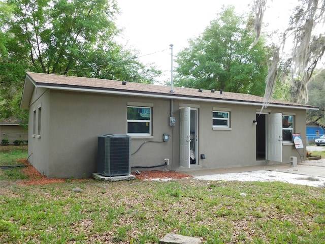 back of house featuring cooling unit and a yard