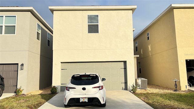 view of front facade featuring central AC unit and a garage