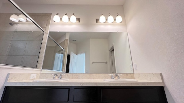 bathroom with vanity and tiled shower