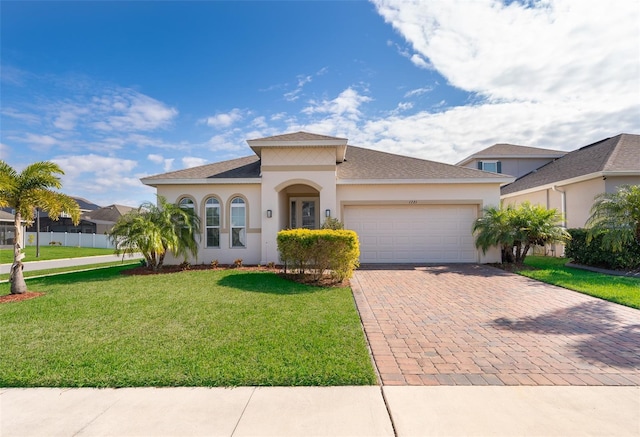 mediterranean / spanish house featuring a garage and a front yard