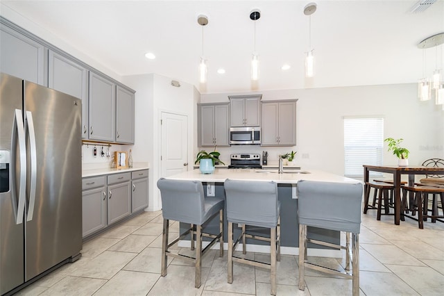 kitchen with pendant lighting, gray cabinetry, and stainless steel appliances