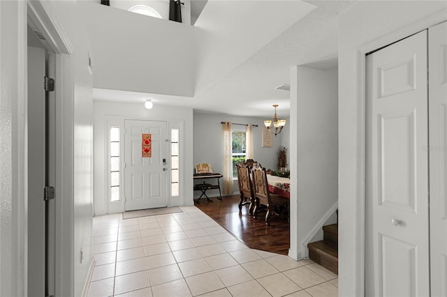 tiled foyer entrance featuring a chandelier and a textured ceiling