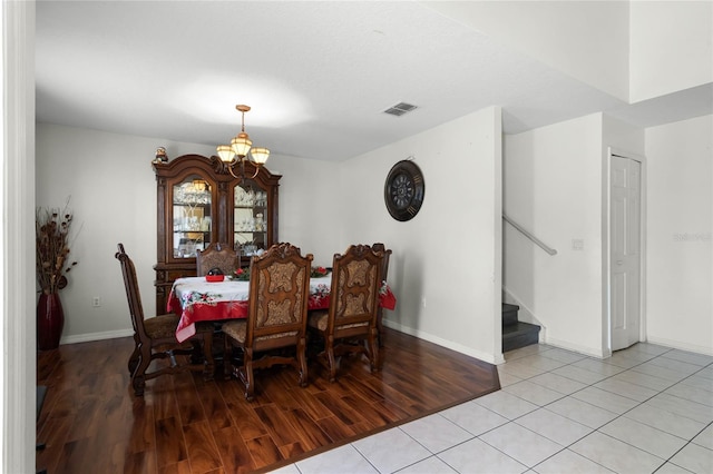 dining space featuring light wood-type flooring and an inviting chandelier