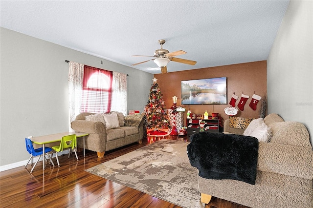 living room with dark hardwood / wood-style floors, ceiling fan, and a textured ceiling