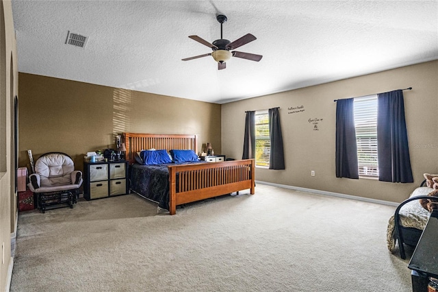 bedroom with ceiling fan, carpet floors, and multiple windows