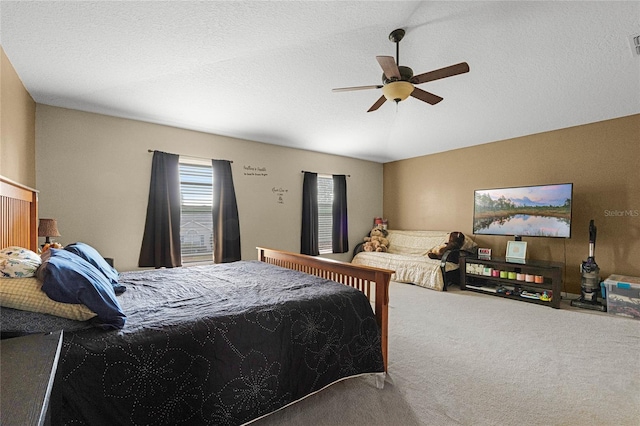 carpeted bedroom featuring a textured ceiling and ceiling fan