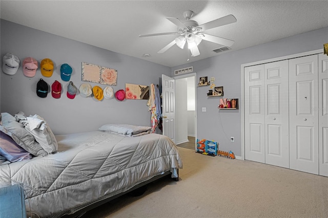 bedroom featuring carpet flooring, ceiling fan, a textured ceiling, and a closet