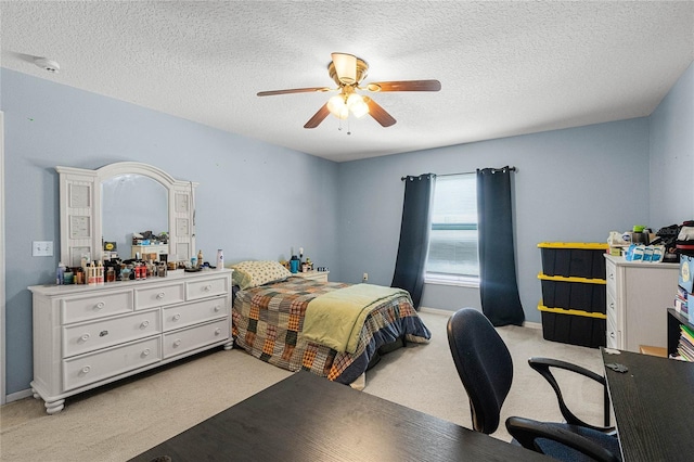 bedroom featuring a textured ceiling, light colored carpet, and ceiling fan