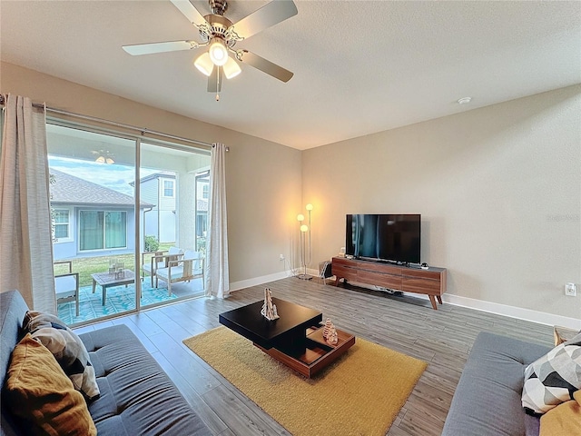 living room with light wood-type flooring and ceiling fan