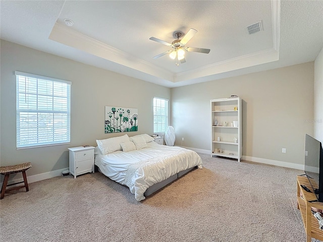 carpeted bedroom with a raised ceiling, ceiling fan, and ornamental molding