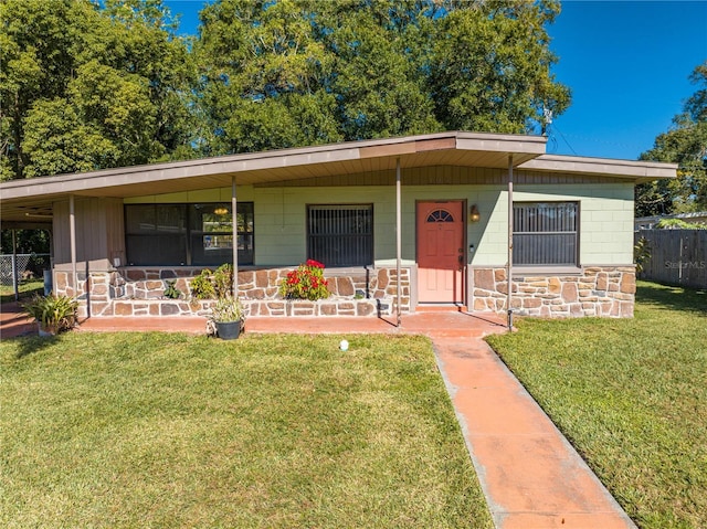 single story home featuring covered porch and a front yard