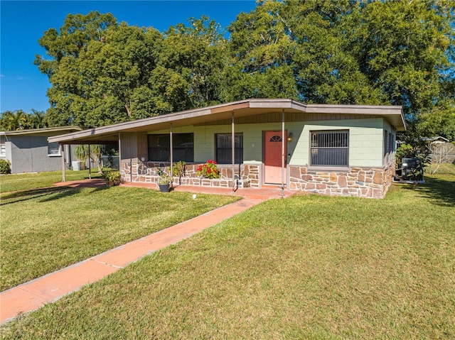 ranch-style home with a porch, a front yard, and a carport