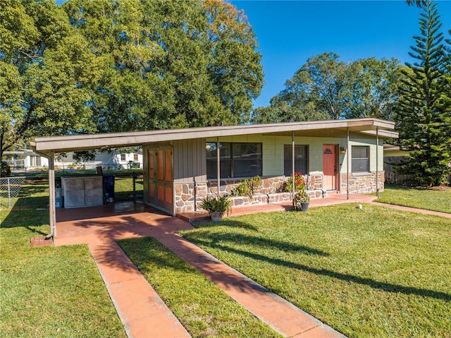 view of front of house featuring covered porch, a front yard, and a carport