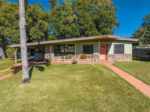 ranch-style house with a front lawn, covered porch, and a carport