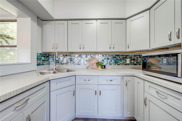 kitchen with backsplash, sink, and hardwood / wood-style flooring