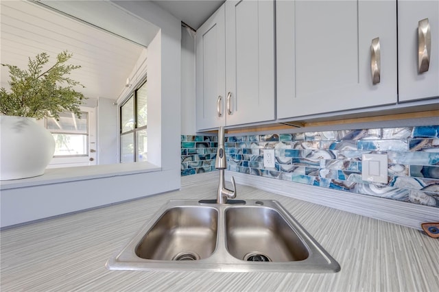 details with white cabinets, tasteful backsplash, and sink