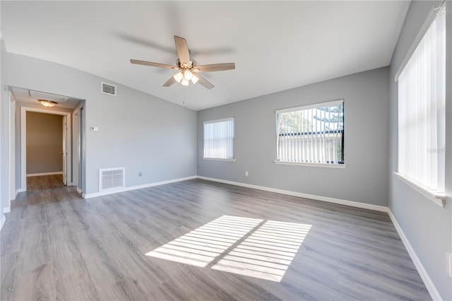 empty room with ceiling fan and light hardwood / wood-style floors