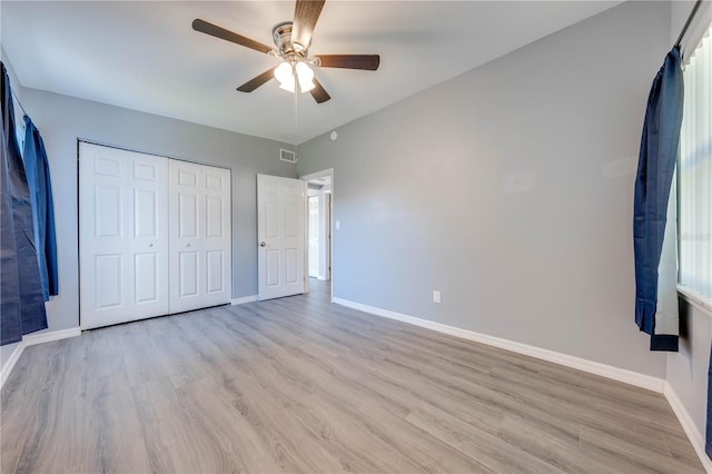 unfurnished bedroom with a closet, light hardwood / wood-style flooring, and ceiling fan