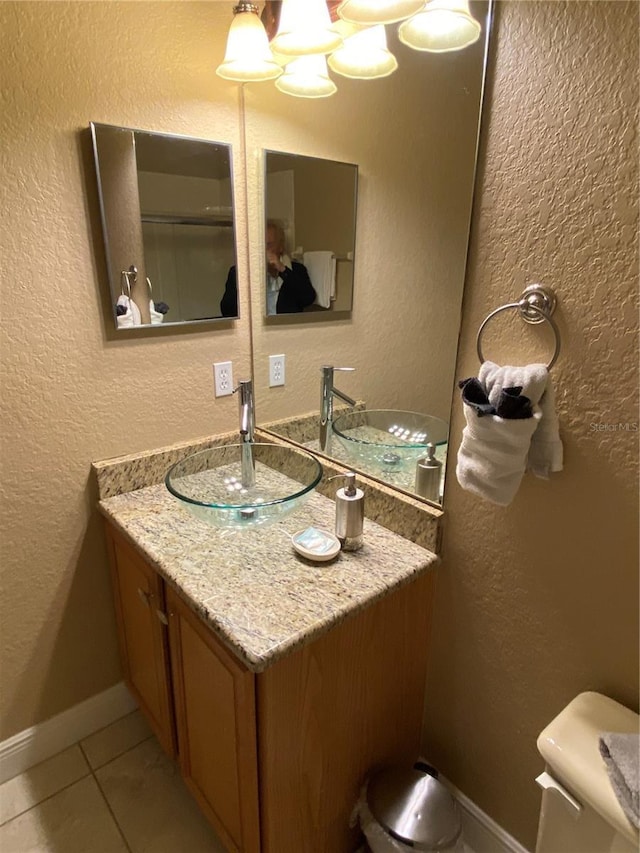 bathroom with tile patterned flooring, vanity, and toilet