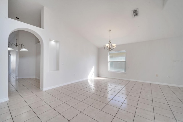 empty room with an inviting chandelier, light tile patterned floors, and high vaulted ceiling