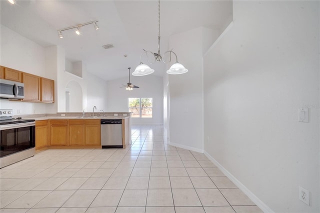 kitchen with pendant lighting, high vaulted ceiling, ceiling fan with notable chandelier, light tile patterned floors, and appliances with stainless steel finishes